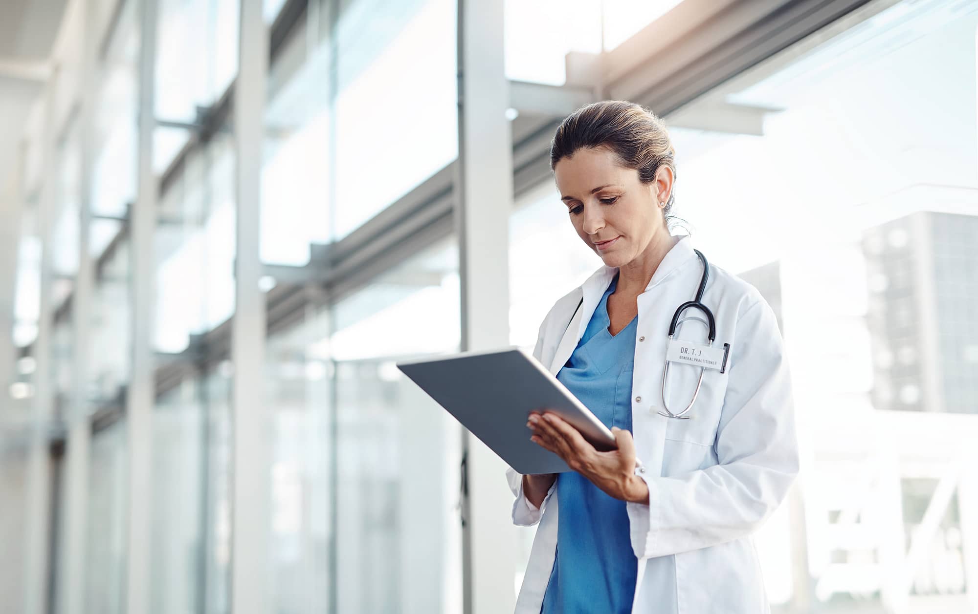 Un médecin femme consultant des dossiers médicaux dématérialisés sur une tablette